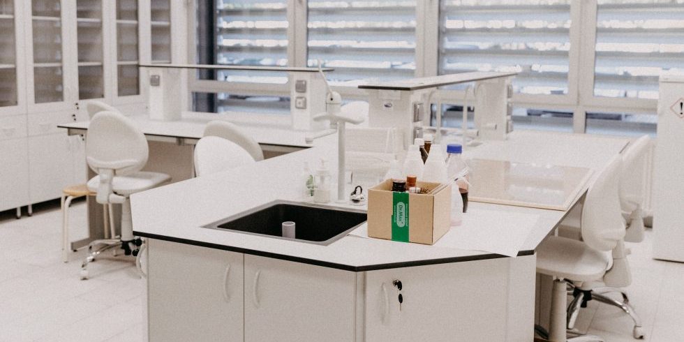 Elegantes Gebäude mit großen Fenstern, begrünten Balkonen und klassischen Lampen.