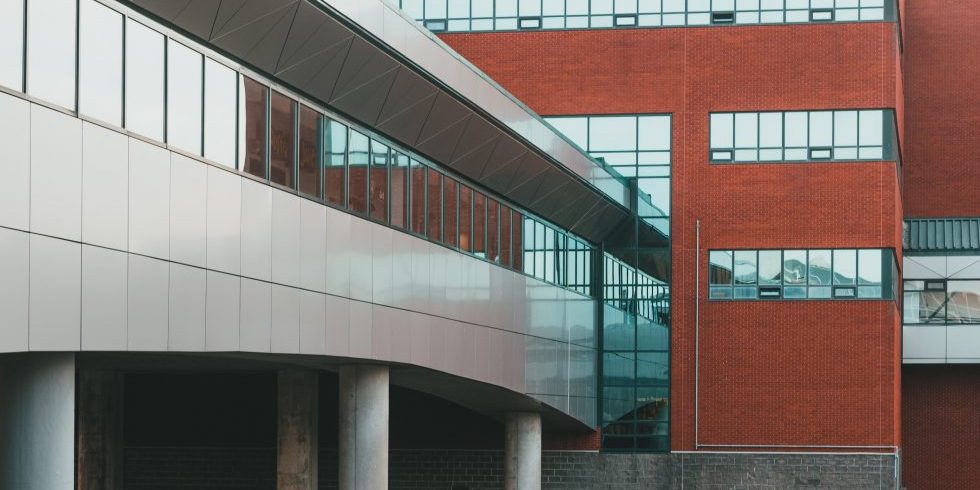 Moderne Architektur mit rotbraunen und grauen Fassaden sowie großen Fenstern.